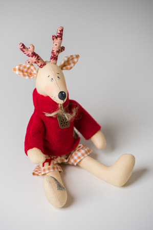 Handmade toy vintage Christmas deer sitting on light backgroundの写真素材
