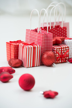 Gift boxes with xmas presents wrapped in red paper with ornamentの写真素材