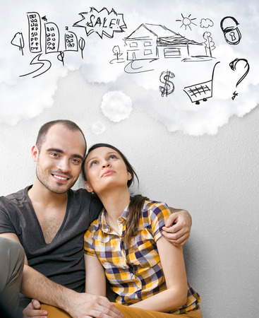 Closeup portrait of adult couple sitting on floor at their apartment and planning renovation of their new apartment while resting during houseworkの写真素材