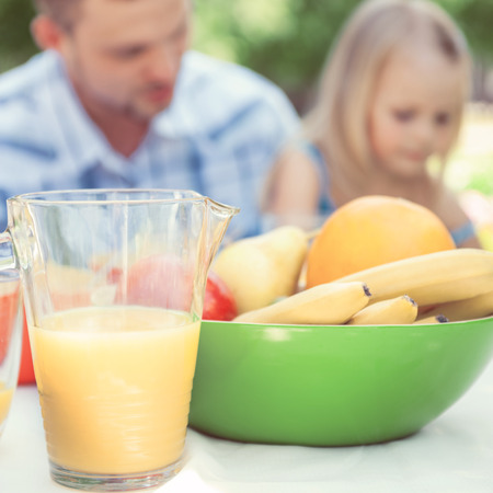 Father and daughter sitting together and talking on background, Focus on foodの写真素材