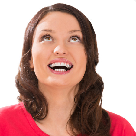 Closeup portrait of charming woman wearing orthodontic braces holding silicone trainer and smilingの写真素材
