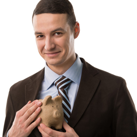 Business man hiding piggybankの写真素材