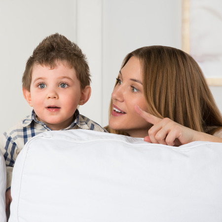 Happy young mother and her cute son playing at homeの写真素材