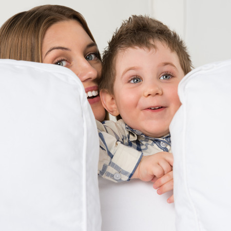 Happy young mother and her cute son playing at homeの写真素材