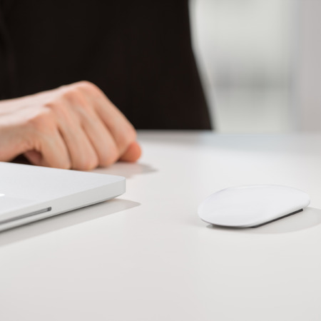 Closeup of torso of confident business man wearing elegant suit working with his laptop at officeの写真素材