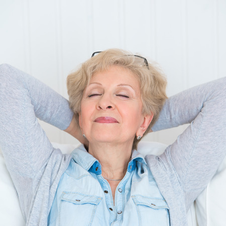 Smiling happy senior woman relaxing at homeの写真素材