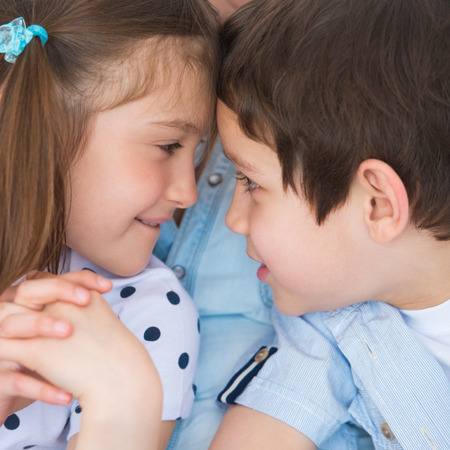 Children competition - boy and girl bumping heads against each otherの写真素材