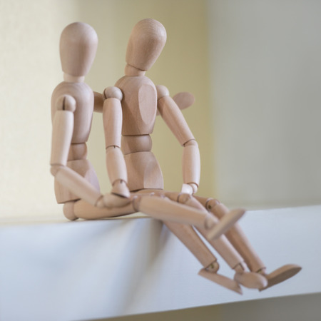 Wooden people sitting at home and hugging. People relationship conceptの写真素材