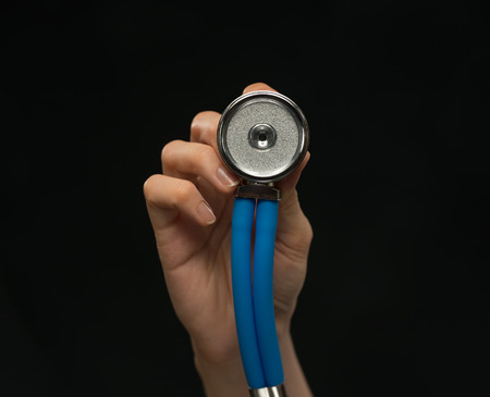 Close-up of female doctor holding stethoscope , focus on stethoscopeの写真素材