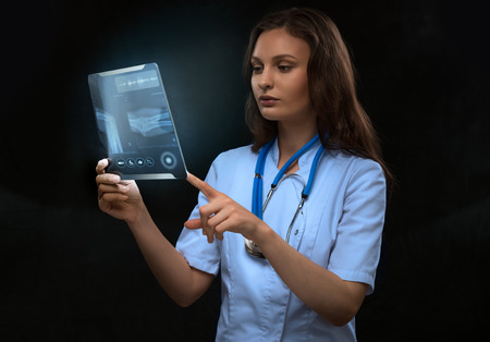 Doctor examining an arm bones radiography using modern tablet computerの写真素材