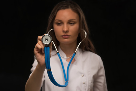 Doctor holding stethoscope and listening