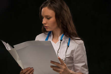 Female doctor reading medical recordの写真素材