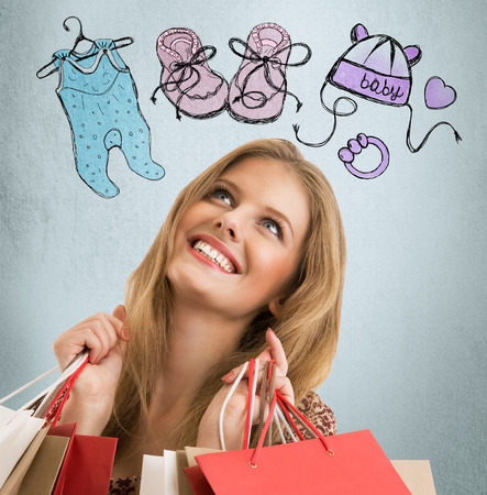 Young woman thinking of her pregnancy plans closeup face portrait and sketches overhead. Planning purchases for newborn babyの写真素材