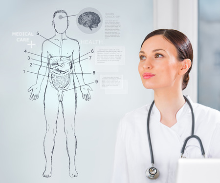 Female medical doctor working with virtual interface examining human male bodyの写真素材
