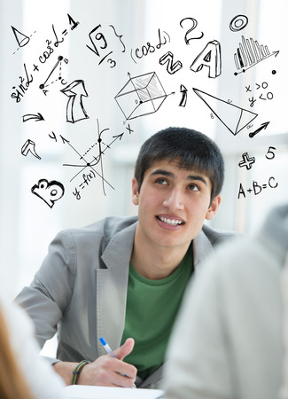 Young guy student at school with math symbols overhead. Education conceptの写真素材