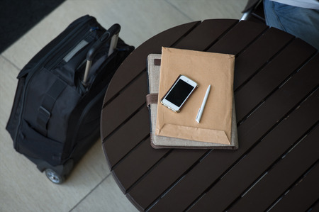 Business concept, smartphone, papers and pen on table at office building or airportの写真素材