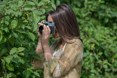 Girl with vintage retro camera. Hipster style.