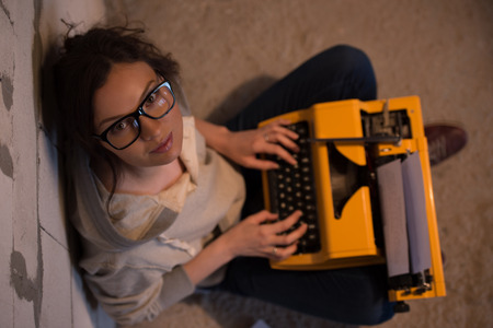 Beautiful woman typing using typewriter. Top view