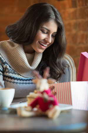 Charming woman in a restaurant opening gift from her couple, Christmas or Valentine's Day romanticsの写真素材