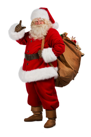 Full length portrait of Real Santa Claus carrying big bag full of gifts, isolated on white backgroundの写真素材