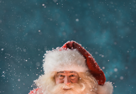 Magical portrait of Santa Claus in snowfall at North Pole. Lots of copyspace