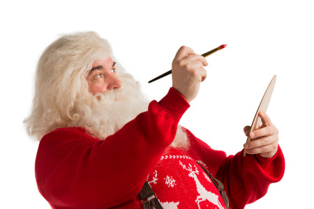 Portrait of Santa Claus painting with brush and palette isolated on white backgroundの写真素材