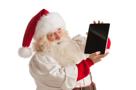 Santa Claus working on tablet computer isolated on white backgroundの写真素材