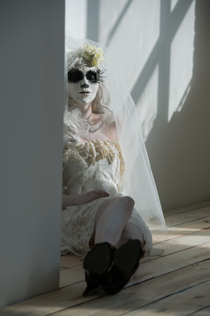 Halloween witch. Beautiful woman wearing santa muerte mask and wedding dress. Dead widow in grief