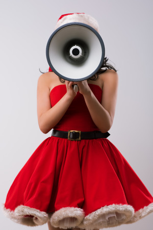 Christmas woman with a megaphone against a white background.の写真素材