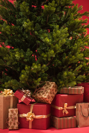 Christmas tree with gifts on red backgroundの写真素材