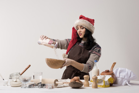 Happy young housewife making christmas cookies in kitchenの写真素材
