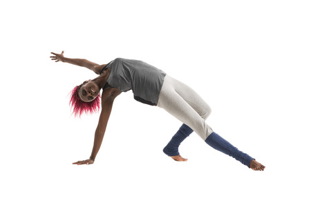Young african woman doing yoga exercises isolated on white backgroundの写真素材