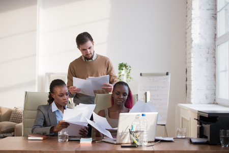 Image of group of three young business people of different ethnicity working togetherの写真素材
