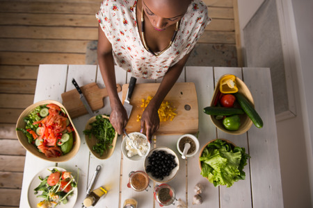 Young African Woman Cooking. Healthy Food - Vegetable Salad. Diet. Dieting Concept. Healthy...