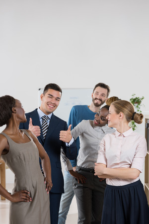 Business team celebrating a triumph with thumbs upの写真素材