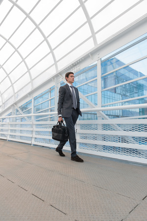 Businessman walking in urban environment of airport or office buildingの写真素材