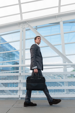 Businessman walking in urban environment of airport or office buildingの写真素材