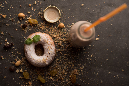 Sugar powder Donut with mint leaf and milk bottle on dark stone backgroundの写真素材