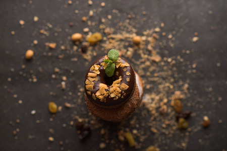 Stack of Donuts with crumbs, nuts and dried fruits on dark stone backgroundの写真素材