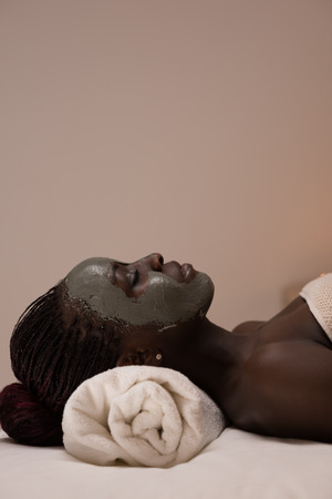 African beauty woman getting mud mask at spaの写真素材
