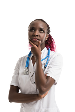 Closeup portrait, young female doctor, health care professional, daydreaming, thinking, looking up at copy space isolated white background. Patient visit health care reform. Human emotion, expressionの写真素材