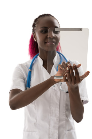 Smiling african doctor using a tablet computer on white backgroundの写真素材