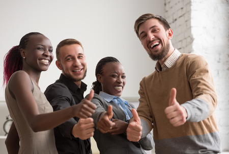 Cheerful business group giving thumbs up