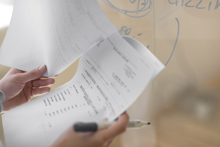 Closeup of female doctor hands holding test results of her patientの写真素材