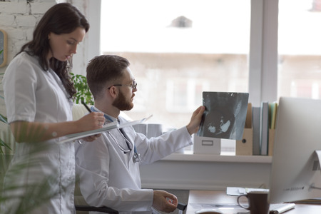 Doctors discussing intestines xray at medical office