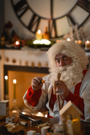Santa Claus at Home making wooden toysの写真素材