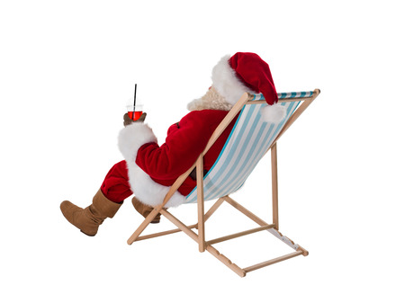 Santa Claus sitting on deck chair and drinking cocktail Full Length Portrait from behind  Isolated on White Backgroundの写真素材