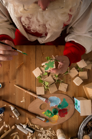 Santa Claus at Home making toys and paintingの写真素材