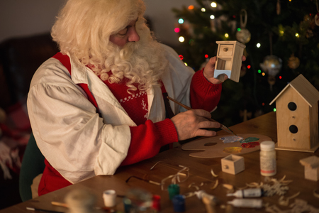 Santa Claus at Home making toys and paintingの写真素材