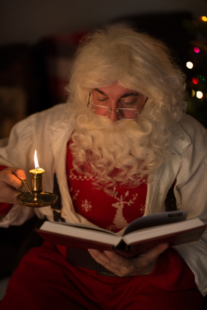 Santa Claus at Home reading bookの写真素材